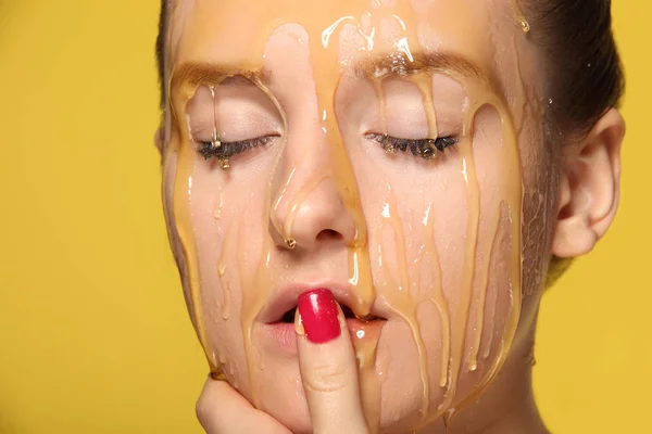 Hermosa mujer con miel en la cara — Foto de Stock