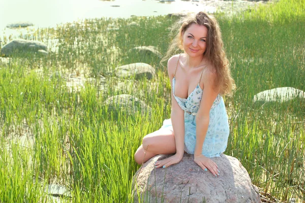 Porträt, das Mädchen sitzt auf einem Stein am Meer — Stockfoto