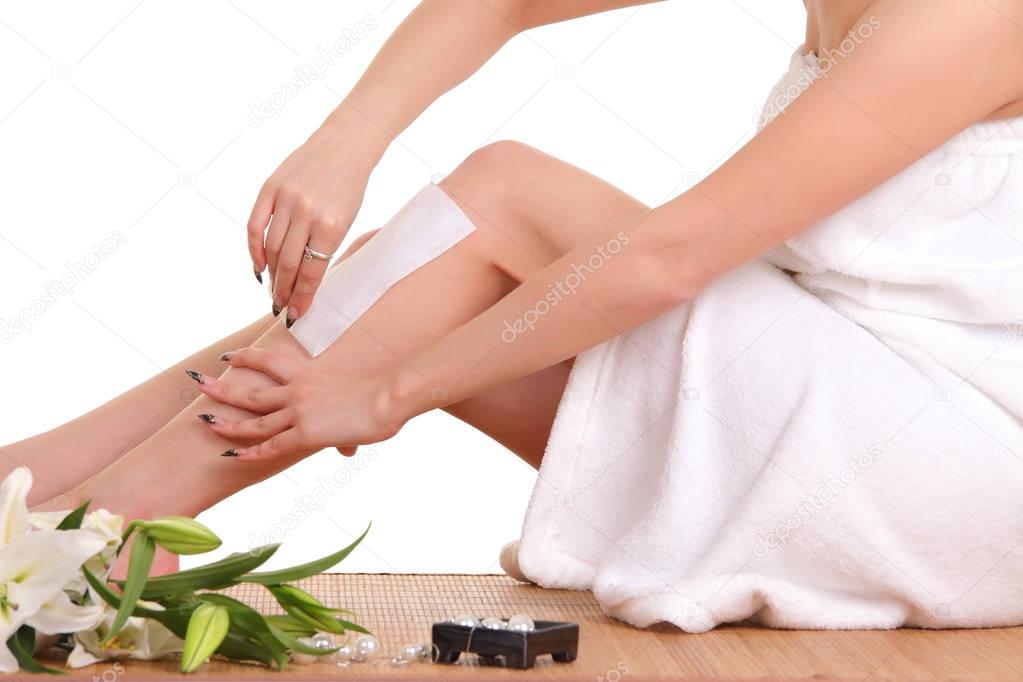 A picture of a young woman waxing her legs
