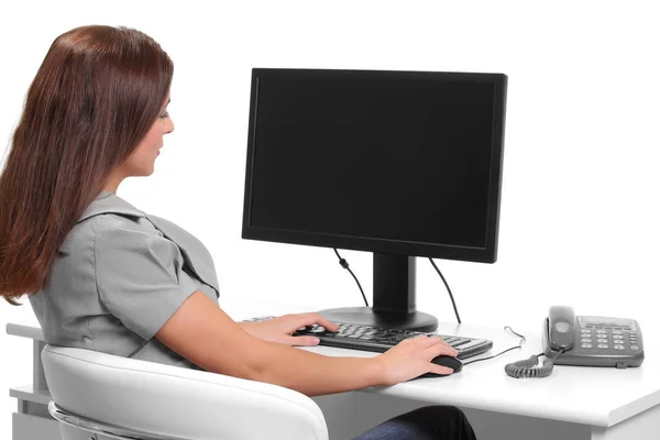 Joven mujer de negocios en el teléfono durante el uso de la computadora en el lugar de trabajo —  Fotos de Stock