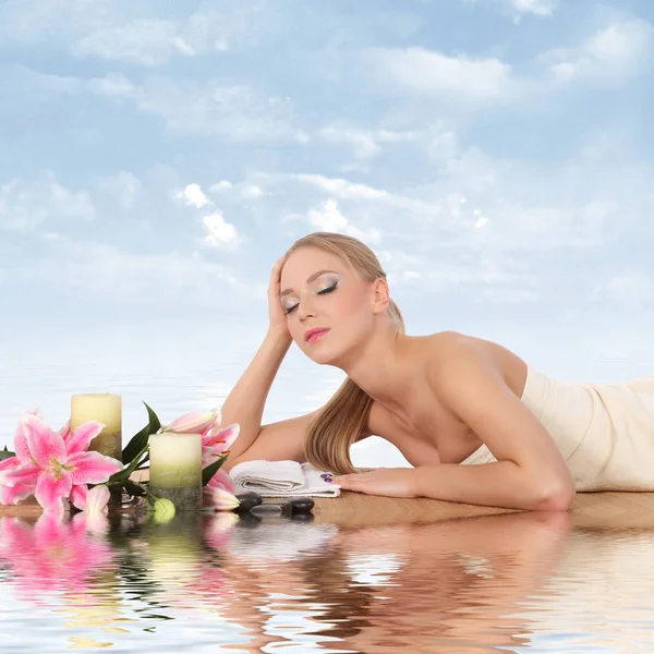 Frau entspannt sich im Wellnessbereich, mit Reflexion auf dem Wasser — Stockfoto