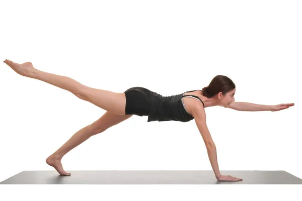 Kobieta robi ćwiczenia jogi, na matę do jogi — Zdjęcie stockowe