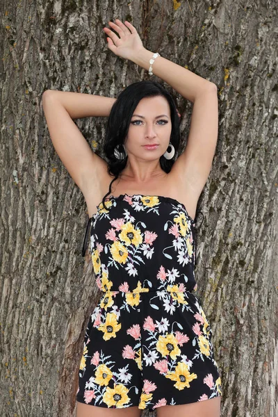 Mädchen im Kleid steht am Baum — Stockfoto