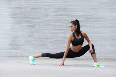 Fitness kız uzanan yapıyor bir spor rakam ile