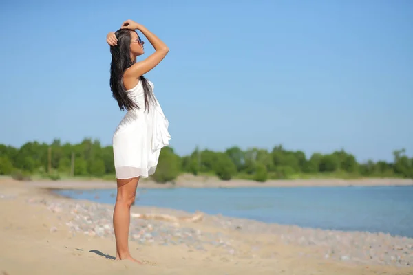 Gelukkige vrouw in witte jurk op het strand — Stockfoto