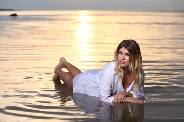 Модна фотографія з красивою жінкою у воді на заході сонця — стокове фото