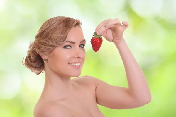 Young woman is eating red berry — Stock Photo, Image