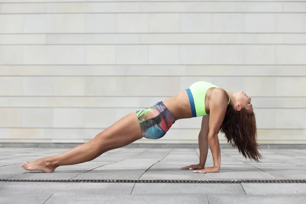 Schöne junge athletische Frau praktiziert Yoga und Plastik — Stockfoto