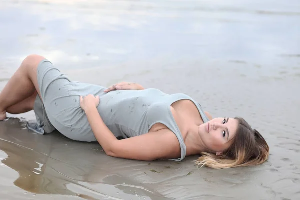 Sexy meisje in het water in een jurk — Stockfoto