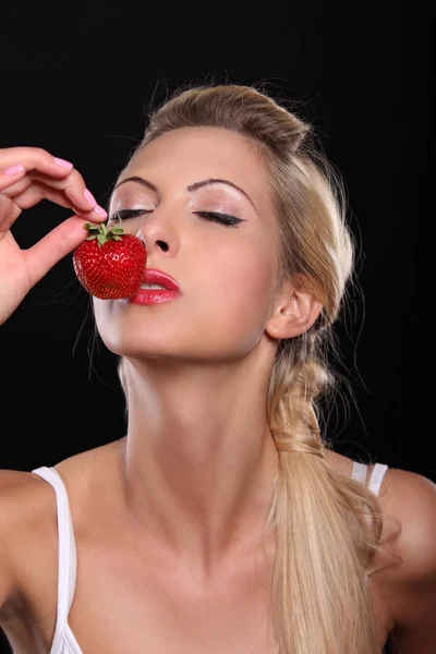 Jonge blonde met een aardbei — Stockfoto