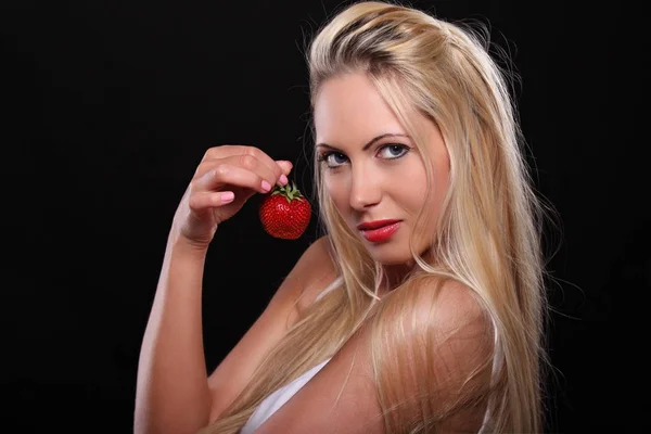 Ung blondin med en jordgubbe — Stockfoto
