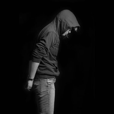 Genç suçlu siyah bir zemin üzerine kelepçeli tutuklandı