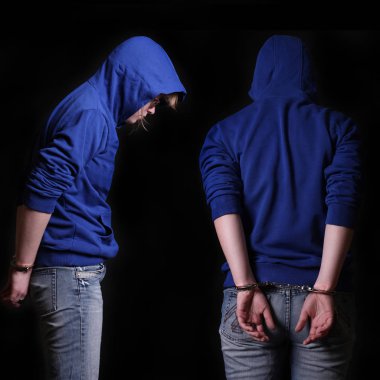 Genç suçlu siyah bir zemin üzerine kelepçeli tutuklandı