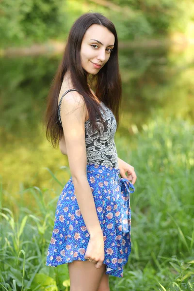 Kız bir arka planda yeşil yaz çayır — Stok fotoğraf