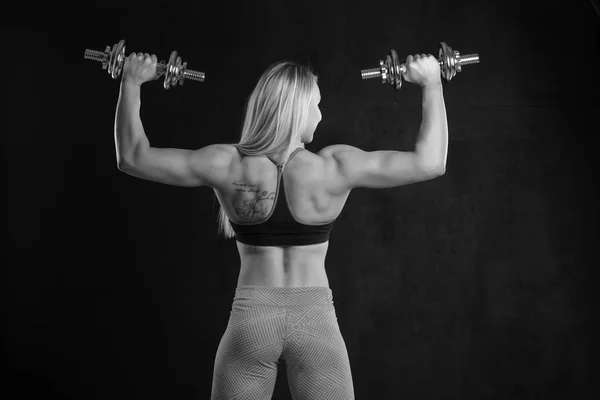 若い筋肉女性がダンベルでポーズ — ストック写真