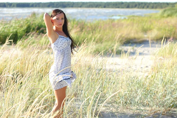 Девушка в летнем белом платье на пляже — стоковое фото