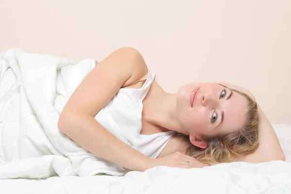 Sonriente dama se encuentra en la cama en el interior . — Foto de Stock