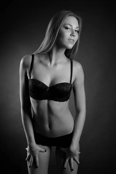 Young sexy girl in underwear on a black background — Stock Photo, Image