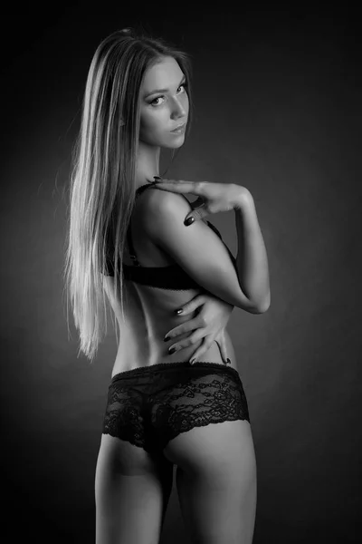 Jovem sexy menina em roupa interior em um fundo preto — Fotografia de Stock