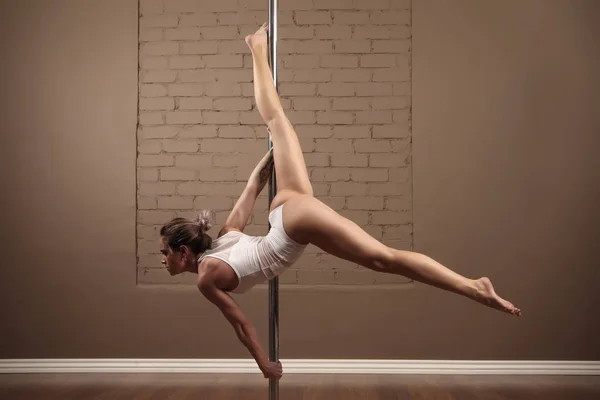 Menina de esportes fazendo acrobacias em um pólo — Fotografia de Stock