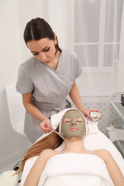 Facial treatment of young woman in a cosmetology salon — Stock Photo, Image