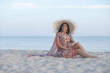 Güzel, mutlu, yetişkin bir kadın sabahın erken saatlerinde sahilde