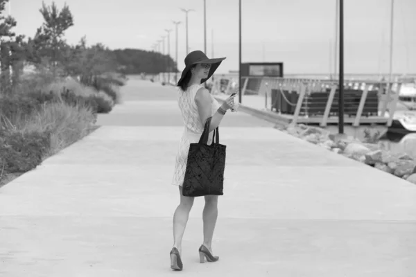 Mulher com saco e cabeça caminha rua abaixo — Fotografia de Stock