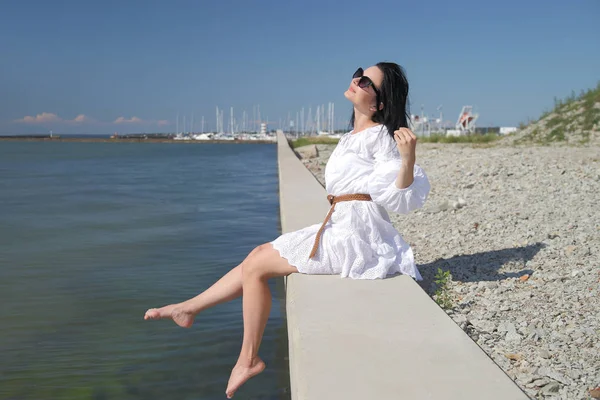 Jovem menina feliz em um vestido branco junto ao mar — Fotografia de Stock