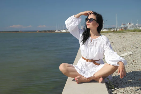 Joven chica feliz en un vestido blanco junto al mar — Foto de Stock