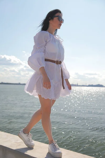 Joven chica feliz en un vestido blanco junto al mar — Foto de Stock