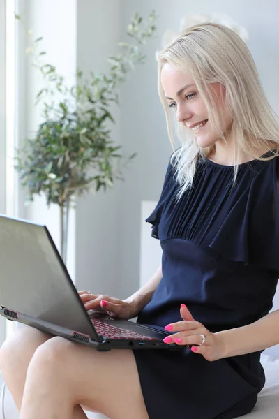Blonde vrouw met laptop — Stockfoto