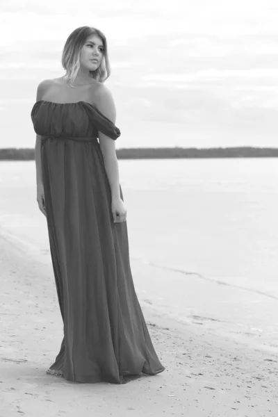 Žena v dlouhých šatech na pláži — Stock fotografie