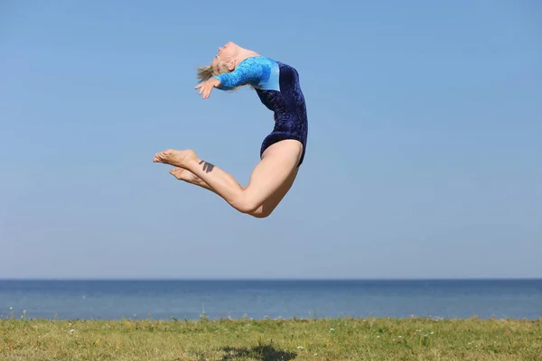 Girl gymnast in a blue bodysuit — Stock Photo, Image