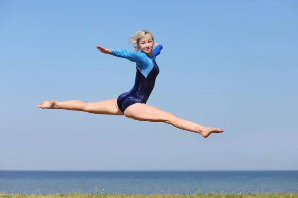 Girl gymnast in a blue bodysuit — Stock Photo, Image