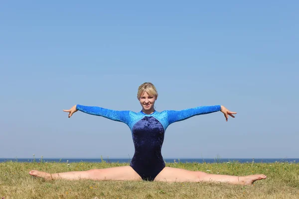 Meisje turner in een blauwe bodysuit — Stockfoto