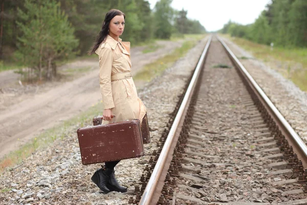 Vrouw met koffer op de rails — Stockfoto