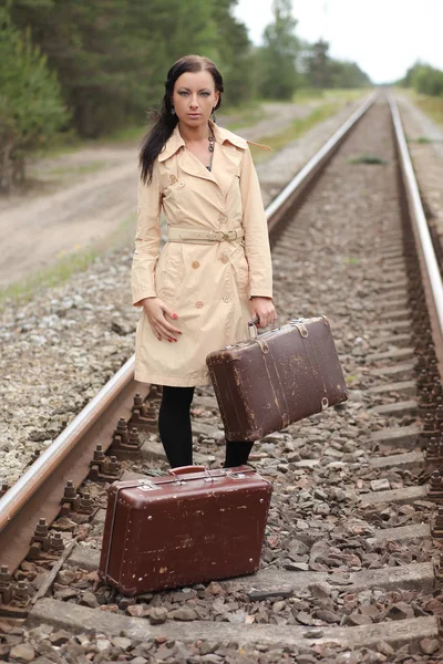 Жінка з валізою на рейках — стокове фото