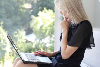 dizüstü bilgisayar kullanan sarışın kadın