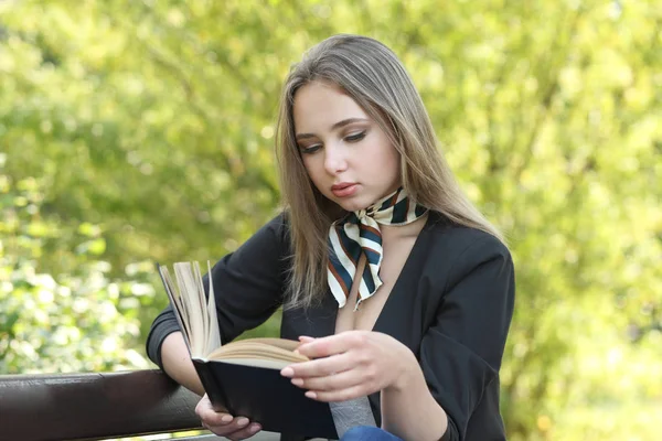 Dziewczyna w parku czyta książkę — Zdjęcie stockowe