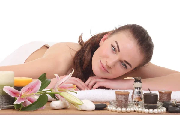 Young woman on massage table with candles — Stock Photo, Image