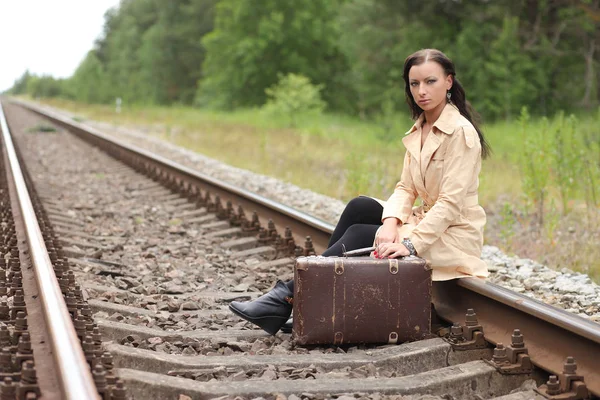 Vrouw met koffer op de rails — Stockfoto