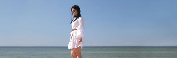 Joven chica feliz en un vestido blanco junto al mar — Foto de Stock