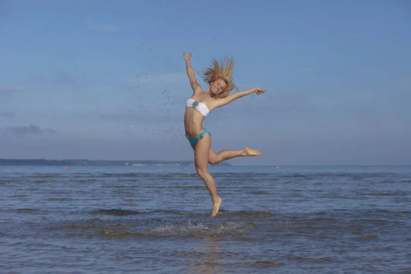 Kvinna hoppar upp ur havet stora stänk — Stockfoto