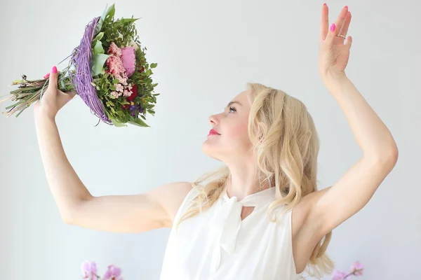 Jeune fille positive avec un bouquet de fleurs — Photo