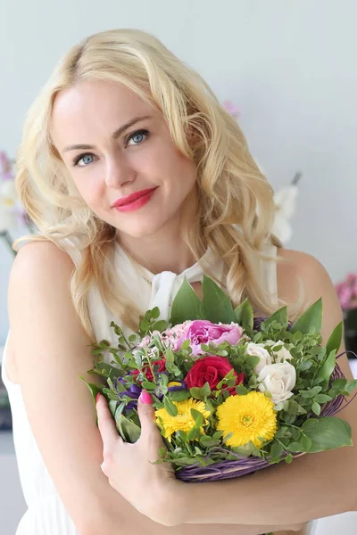 Jong positief meisje met een boeket bloemen — Stockfoto