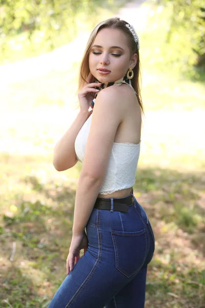 Ung söt flicka i en vit tank top och blå jeans — Stockfoto