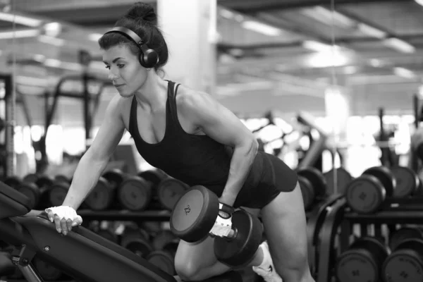 Chica joven fitness en el gimnasio haciendo ejercicios —  Fotos de Stock