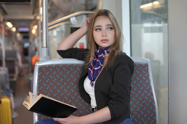 Красивая девушка в трамвае читает книгу — стоковое фото