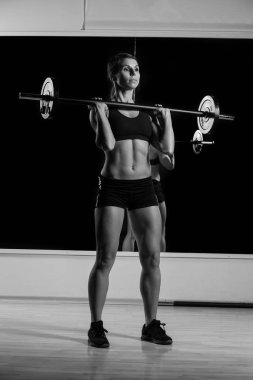 Genç güçlü kız halteri kaldırıyor.