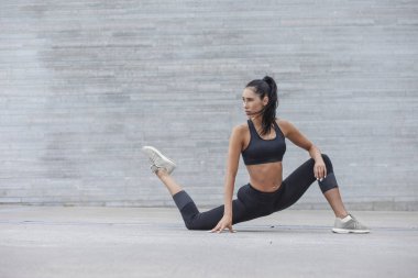 Fitness kız uzanan yapıyor bir spor rakam ile